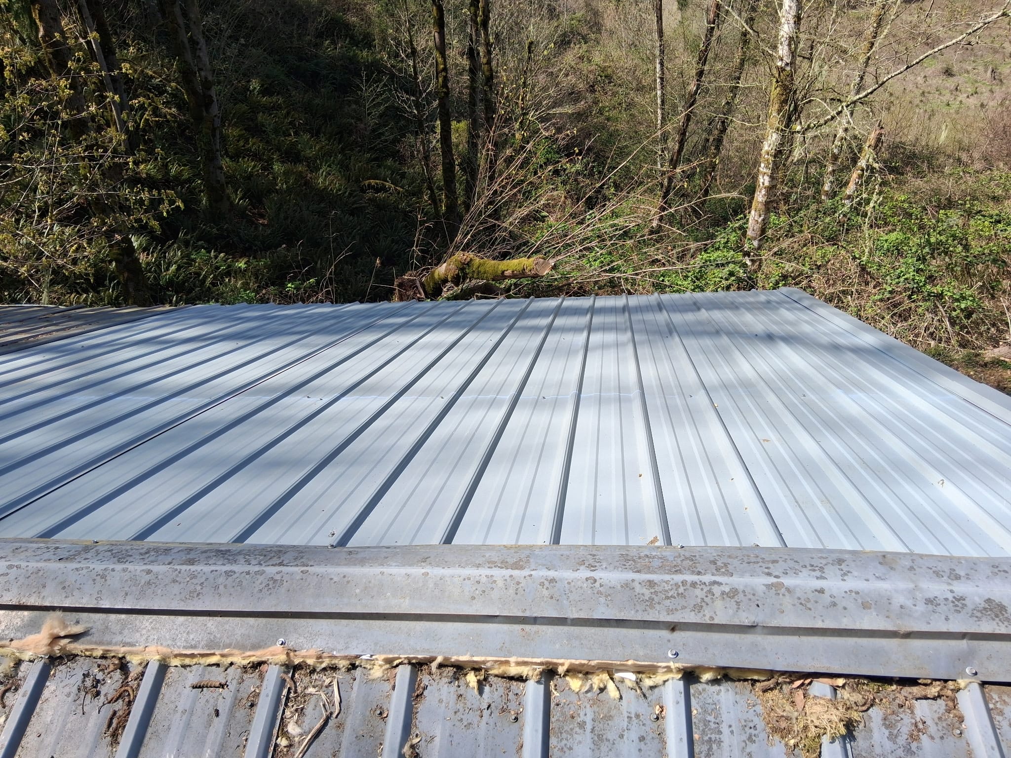 New ribbed metal roof panel installed during a leak and storm-damage repair