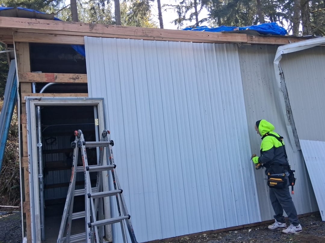 TK Construction installing corrugated metal siding during a roof repair